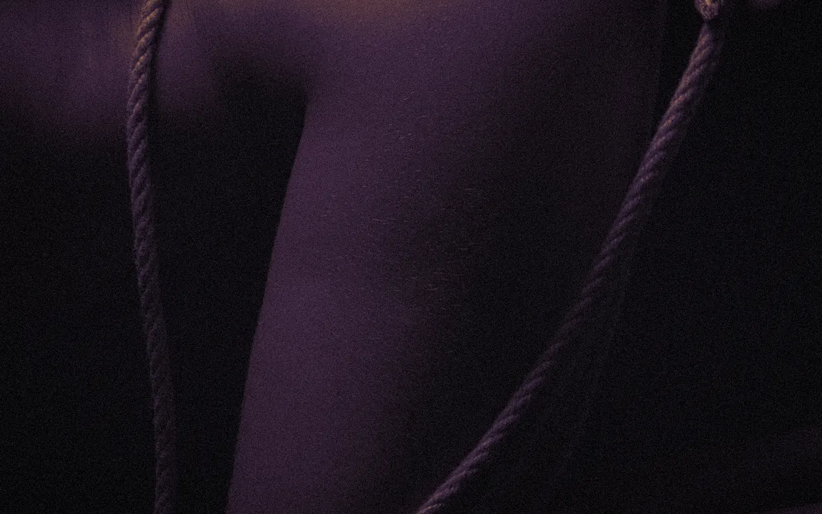 Rope over a shoulder, a hand holding the loose end